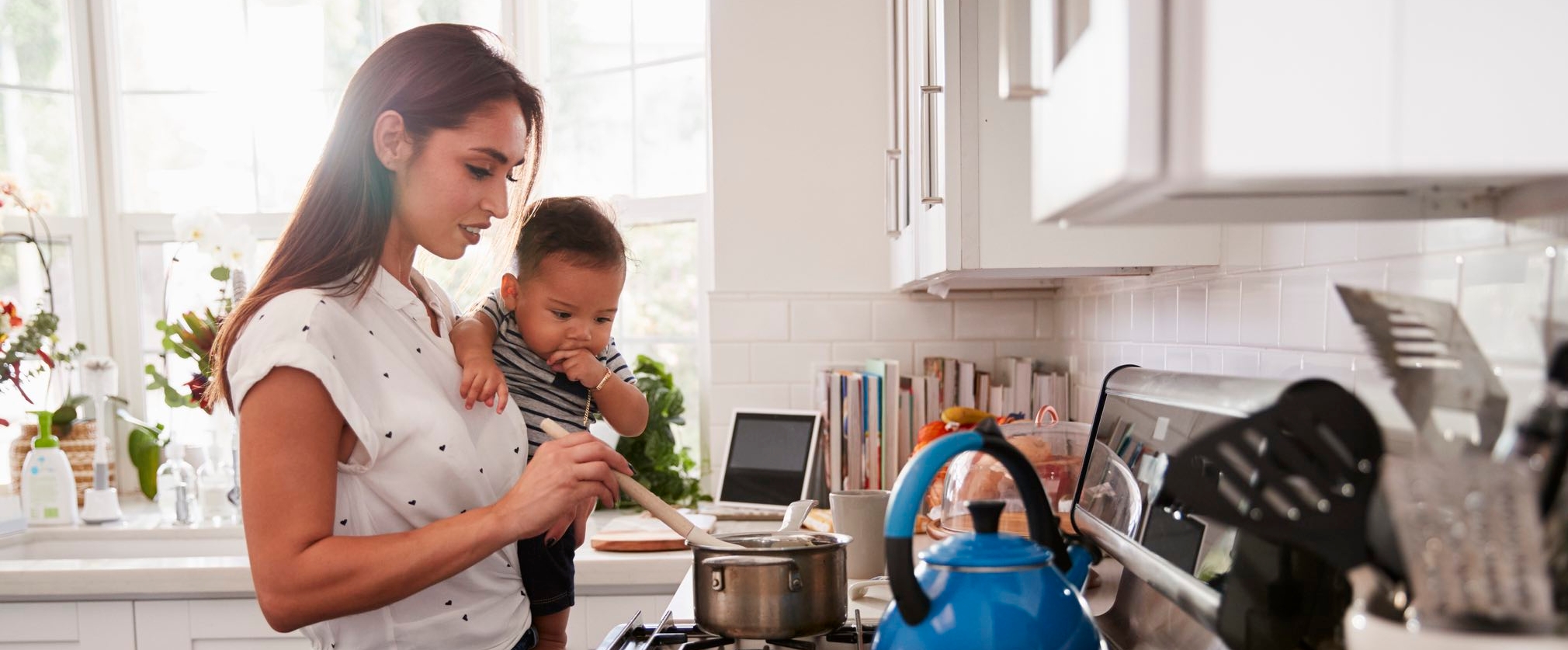 mom cooking at stove with baby